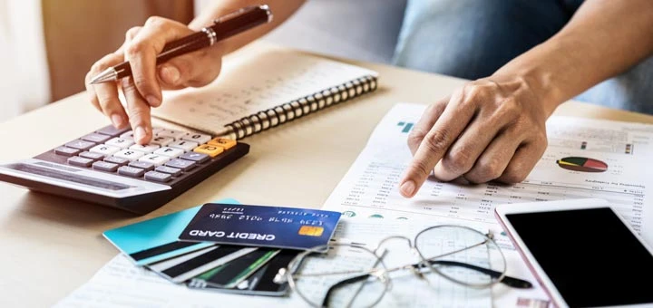 hombre papeles calculadora tarjetas crédito deudas